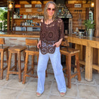 Polera de tejido crochet café con calados de flores sobre jeans celeste de pierna ancha – vista 2